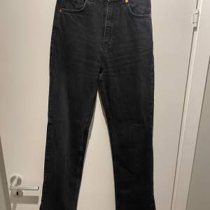 Högmidjade svarta jeans med en slits längst ner, från Bik Bok. Storlek 26/32