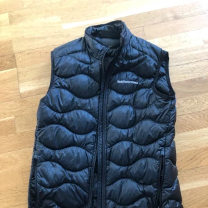 Peak performance väst stl S  - Fint skick. Finns ett litet märke längs ner på västen. 