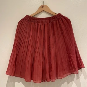 Plisserad kjol - Plisserad kjol med några små skavanker där trådar släppt, dock ingenting som syns när man har på sig kjolen. Storlek XS men är elastisk i midjan och väldigt flowy i övrigt så passar XS-M skulle jag säga.