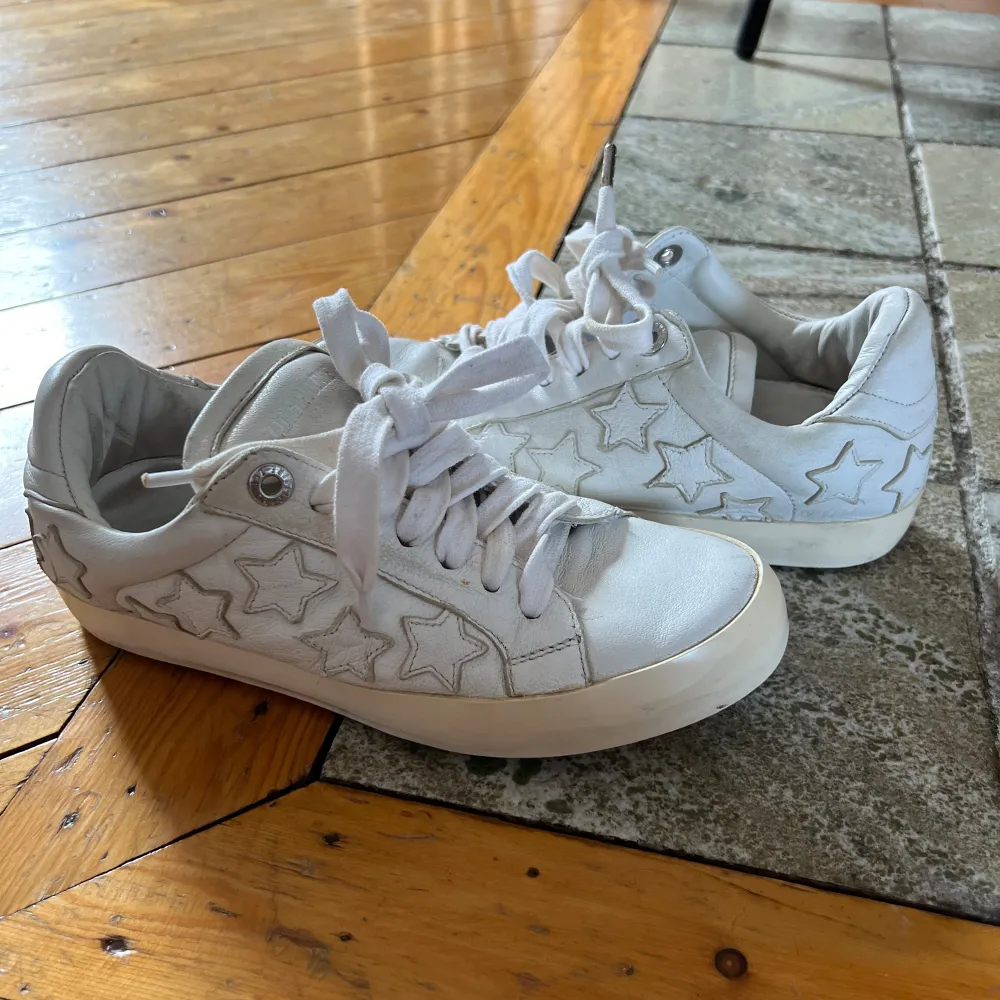 Vita sneakers med stjärnor från Zadig & Voltaire i storlek 37. 100% läder. ”Used effect” från början, hade smuts/slitningar pga modellen men är använda och har några skavanker pga användning, syns inte så mycket pga modellen💓. Skor.