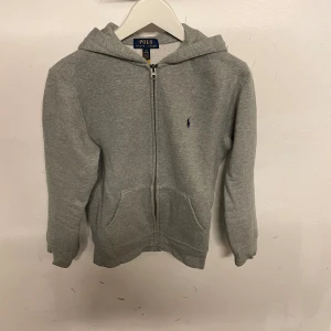 Ralph lauren grå zip hoddie - Ralph lauren zip hoddie grå. Storlek 14/16 år (164). Ny skick knappast använd. Nypris 999 kr