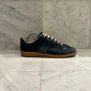 Maison Margiela GAT’s - Säljer nu dessa otroligt feta och trendiga Maison Martin Margiela GAT’s. Skorna är i mycket bra skick ~ 8.5/10 - Endast skorna medföljer - Nypris: 7000 kr - Storlek: 40 men passar 41 - Hör av er vid minsta fråga eller fundering :)