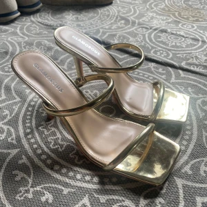 Guldiga klackskor  - (Sista 2 bilderna är lånade) Aldrig använt skorna, enbart testade! Klackarna upplever jag stämmer bra med storleken. Sjukt stilrena skor som samtidigt är dedär lilla extra❣️