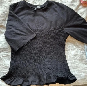 Smockrad topp! - säljer denna jätte fina svarta t-shirt med smockrad midja! Storlek XS men passar mig som är S i vanliga fall. Säljer då den inte kommer till användning, använd 2 gånger! 