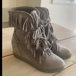 Gråa fransskor - Följ mig gärna då jag lägger upp liknande plagg 🌼 Säljer dessa supersnygga kilklack skor med fransar. De är i storlek 41 och i perfekt skick. Skriv gärna om du har frågor eller köp direkt via köp nu ❤️