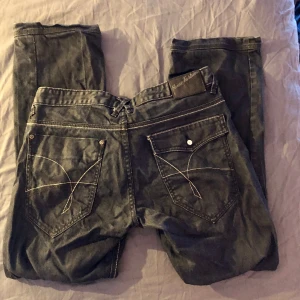 Asfeta jeans med vita sömmar - Mörkblå jeans med synliga vita sömmar. Ascoola. Sitter lite löst men inte superbaggy. Storlek: 36/32.