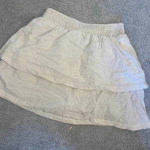 Kjol H&M - En beige vit randig kjol, bra skick. Kjolen är i strlk M men  passar mig som är oftast en S och är 172!!  
