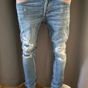 Dondup George  - Dondup Jeans George! Trendigaste jeansen på marknaden. Skick= 7,5/10 Ny pris= 4000 kr Säljs för= 1099 kr (modellen är destroyed från fabrik vilket är väldigt populärt, finns ett hål där hud syns men det är ett orginal hål och ska vara där! Bra att veta för informationens skull