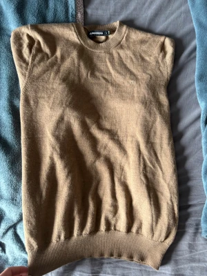 Beige stickad tröja J.Lindeberg - Säljer denna jättefina tröjan från J.Lindeberg. Den är i merinoull och strl M men sitter lite mer som S. Jag är 189,77kg och på bilderna kan ni se hur den sitter på mig. Nypriss är 999kr, mitt pris 549kr. Den är i utmärkt skick med inga tecken på användning.