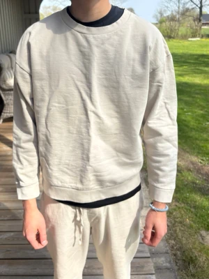 Beige oversized sweatshirt - En stilren beige oversized sweatshirt med rund halsringning och långa ärmar. Tröjan har en avslappnad passform och ribbade muddar vid ärmslut och nederkant. Perfekt för en chill och trendig look.