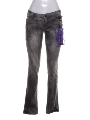 Grå vintage y2k lågmidjade bootcut jeans med stenar - Snygga lågmidjade low waist grå bootcut jeans med coolt mönster och dekorativa stenar på framsidan. Jeansen har låg midja, klassiska fickor och en unik tvättad look. Perfekta för dig som vill sticka ut med en edgy stil. NY MED PRISLAPP!