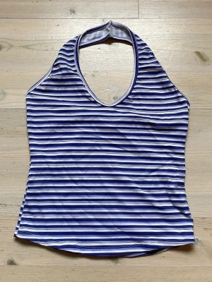 Randig halterneck topp - Säljer snygg lilavit randig halterneck topp. Tunt tyg som är lite träningskläder aktigt som sitter tajt och blir även perfekt på en varm sommardag. Jag har aldrig använt denna men köpt second hand, enda defekten jag hittar ser ni på sista bilden (titta på vita ränderna så ser du). Jättebekväm och snygg! Finns ingen lapp kvar alls. 