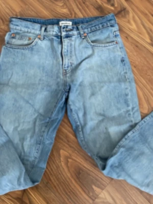 Ljusblå raka jeans från Woodbird - Säljer ett par ljusblå jeans från Woodbird med klassisk femficksmodell och raka ben. Jeansen har en avslappnad passform och är tillverkade i denim med synliga sömmar och kopparfärgade nitar. Perfekta för en casual look. W30 32L