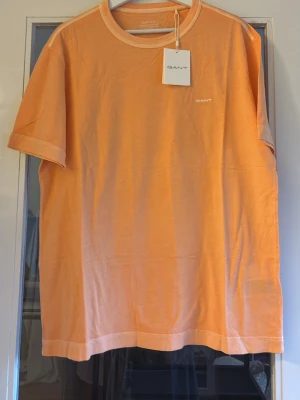 Orange t-shirt från GANT helt ny med tag aprikos  (nypris 650)  - Fräsch orange t-shirt från GANT med diskret logga på bröstet. 