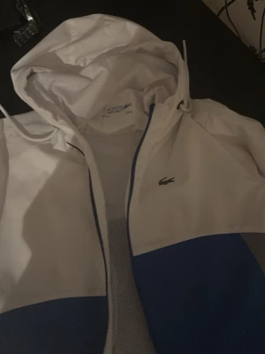 Lacoste windbreaker - Riktigt nice lacoste jacka, luftig och är perfekt till en sommarkväll. Pris kan diskuteras. L i storlek men passar dessutom M. Oanvänd