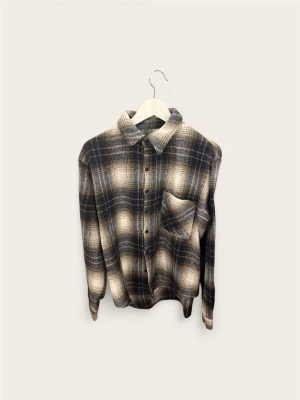 Overshirt / Skjortjacka – Rutig (Grå/Brun/Beige) – Stl S - Säljer en snygg och rutig overshirt/skjortjacka i en stilren färgmix av grått, brunt och beige. Skön passform och fungerar perfekt som ett värmande lager över en t-shirt eller tröja.  Specifikationer:  Märke: Okänt  Typ: Overshirt / Skjortjacka / Flanell  Storlek: S  Färg: Rutig (Grå/Brun/Beige)  Skick: Fint begagnat skick. Mitt hem är helt djur- och rökfritt.  Finns i Bromma. Snabb och smidig affär prioriteras.