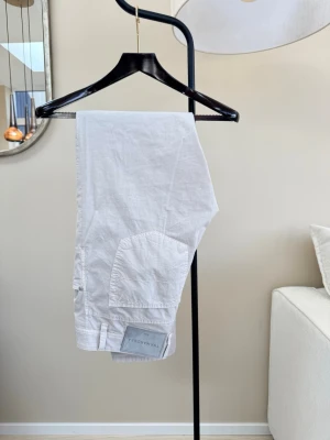 Tramarossa chinos – aldrig använda - Vita chinos från Tramarossa, modell Leonardo. Premiumbyxor tillverkade i Italien i stretchbomull med en modern slim passform och klassiska detaljer från Tramarossa, bland annat signaturknappar och avtagbar name plate. Väldigt hög kvalitet och perfekt sommarbyxa eller till smart casual.  Storlek 38 (W38 / ungefär EU 54). Midja 44 cm (88 cm omkrets), innerben 86 cm, ytterlängd 109 cm, front rise 22 cm och benslut 17 cm.  Skick: aldrig använda. Nypris ligger runt 3000–4000 kr.