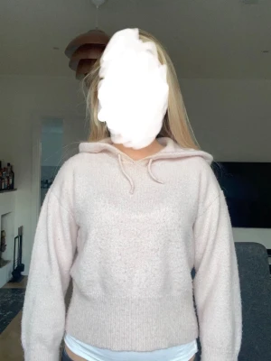 Ljusrosa hoodie med snörning - Mysig ljusrosa hoodie med huva och snörning. Hoodien har lång ärm och ribbade muddar vid ärmslut och midja. Perfekt för en avslappnad och chill stil. Tillverkad i mjukt material som känns skönt mot huden.