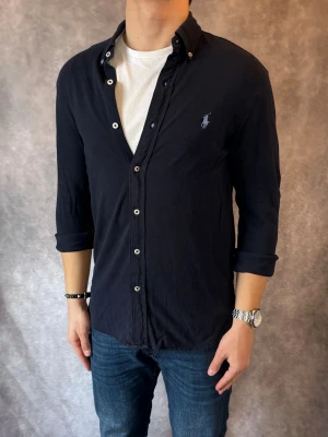 Marinblå Ralph Lauren Skjorta - Stl S, FEATHERWEIGHT MESH - RIKTIGT FET RL SKJORTA I FÄRGEN MARINBLÅ MED SNYGGA DETALJER, perfekt till sommaren som närmar sig! 🏖️🌊 | Mycket bra skick: 9,5/10, utan defekter! | Stl: S  |  Modellen är 176cm och väger 75kg,  | Hör av dig vid frågor // Galgen 🫡