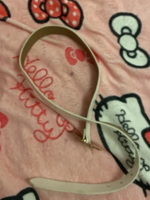 Vitt smalt bälte med gulddetalj - Snyggt och stilrent vitt bälte med smal design och guldfärgat spänne. Perfekt för att lyfta vilken outfit som helst och passar till både jeans och klänning. Enkel att justera med flera hål längs remmen.