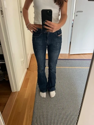 Mörkblå bootcut jeans från Diesel - Säljer ett par mörkblå bootcut jeans från Diesel med klassisk femficksdesign och snygga kontrastsömmar. Jeansen har normal midja och är tillverkade i en mjuk bomullsblandning med lite stretch för extra komfort. Storlek 12år/156cm