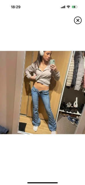 Low waist jeans från j’adore - Säljer ett par ljusblå bootcut jeans med låg midja och snygga broderade detaljer på bakfickorna. Jeansen har klassisk femficksmodell och är tillverkade i stretchigt denimtyg för skön passform. Perfekta för dig som gillar retrovibbar och vill ha ett par jeans som sticker ut.