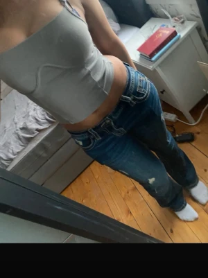 Ljusgrå bandeau topp från H&M - Säljer en ljusgrå bandeau topp från H&M:s DIVIDED-kollektion. Toppen är axelbandslös och croppad, perfekt för dig som gillar en enkel och stilren look. Materialet är mjukt och stretchigt för en bekväm passform.