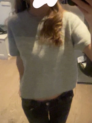 Ljusgrå stickad tröja från Gina Tricot - Mysig ljusgrå stickad tröja från Gina Tricot med korta ärmar och rund hals. Tröjan har en enkel och stilren design i mjukt material. 