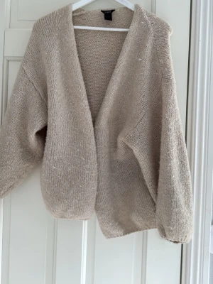 Beige stickad cardigan från Lindex - Mysig beige stickad cardigan ifrån Lindex, som även trendar. Koftan är i storlek M/L fast ganska liten i storlek. Koftan kan både användas till hemmabruk men även till andra tillfällen.