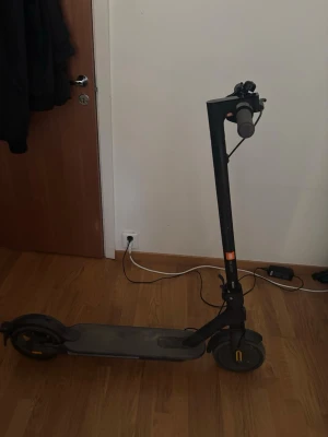 Svart elscooter med laddare 25km/t - Säljer en svart Xiaomi elscooter med grå handtag och gula detaljer på hjulen. Jag kan mötas upp i Solna och Sundbyberg.Scootern går i 25km/t och har en räckvidd på 40km. Scootern har en stilren design och laddas via medföljande laddare. Perfekt för att ta sig runt vart som helst.