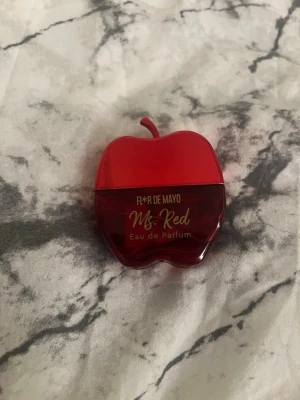 Fleur de Mayo Ms. Red parfym - Säljer en parfym från Fleur de Mayo med namnet Ms. Red. Flaskan är formad som ett rött äpple och har en blank finish. Parfymen är en Eau de Parfum och flaskan är tillverkad i plast. Perfekt för dig som gillar unika och färgglada flaskor, 20ml. Äppel lik doft lite rosig och kvinnlig. (Oanvänd).