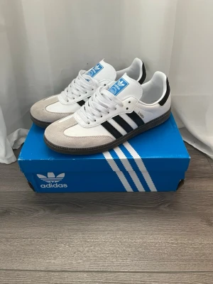 Adidas Samba OG i vitt/svart - Använda få gånger, mycket fint skick nästintill nya. Storlek: 42 2/3 Orginalbox ingår! Öppen för seriösa bud.