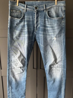 Ljusblå dondup ICON jeans  - Säljer ett par ljusblå jeans med smal passform och perfekta nu till sommaren☀️. Jeansen har klassisk femficksdesign och är tillverkade i denim med lätt stretch. De är modellen icon vilket gör att de är lite mer lösa i passformen och är i storlek 33. Dessa är köpta i butik och ej på Plick vilket resulterar i att de har en bättre och nyare kvalité! Nypris på dessa ligger på 3500kr! (Pris går att diskuteras)