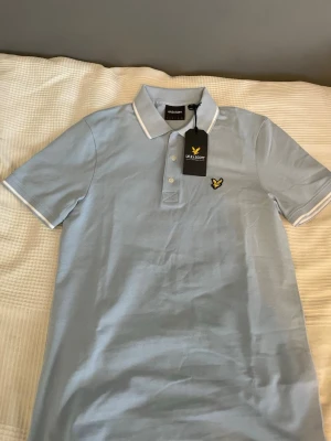 Lyle and Scott golfpike  - Säljer nu en helt ny piké som jag fick i present men som inte föll mig i smaken riktigt. Fin ljusblå färg som passar bra på sommaren. Storlek S och sitter slim fit. Nypris 599. Mitt pris 399. Kan gå ner i pris vid snabb affär. 