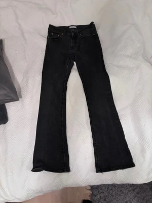 Svarta bootcut jeans - Säljer ett par svarta bootcut jeans från ginatricot. Dom är lite urtvättade och slitna vid nederkant. 