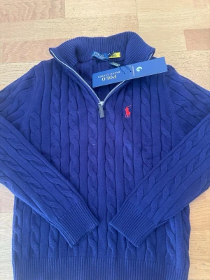 Blå kabelstickad tröja Polo Ralph Lauren - I bra skick, alla lappar kvar har även NFT Scan, väldigt liten i storlek passar för XS S  