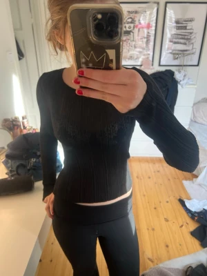 Svart genomskinlig ribbad långärmad topp Lindex - Svart långärmad topp från Lindex i ribbat material. Toppen har rund halsringning och sitter tight mot kroppen. Perfekt att styla med jeans eller kjol för en snygg och enkel look.