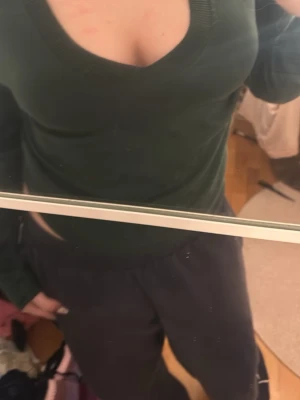 Mörkgrön v-ringad tröja - Mörkgrön långärmad tröja med djup v-ringning och ribbade muddar vid hals, ärmslut och nederkant. Perfekt att styla med jeans eller kjol för en clean look. Pris kan alltid diskuteras