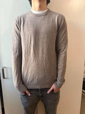 These Glory Days merinoull tröja  - En stilren beige stickad tröja med rund halsringning och långa ärmar från These Glory Days, 100% merinoull och nyskick använd max 4 gånger, nypris-999kr mitt pris-400kr, storlek L men passar mer som M