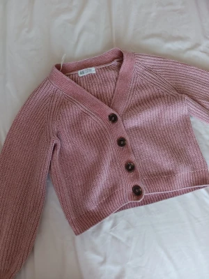 Rosa stickad kofta från H&M - Mysig och söt rosa kofta från H&M för endast 45 kr + frakt! 💰Inkluderar även en basic rosa t-shirt som funkar perfekt tillsammans med koftan!🌸🩷 Storlek 134/140- alltså 8-10 år