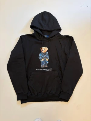 Svart Ralph lauren polo bear hoodie L - Svart Ralph Lauren Polo bear hoodie //  Mycket bra musik skick aldrig använd //  Storlek L //  Mått  Längd  68cm Axelbredd  53cm Bredd mellan armhålorna 54cm Armlängd  62cm Skriv vid minsta fråga eller fundering🤝