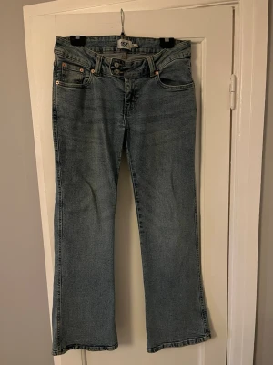 Blå bootcut jeans från 157 - Snygga blå lågmidjade bootcut jeans från 157 med broderade detaljer på fickorna. Stretchigt material.