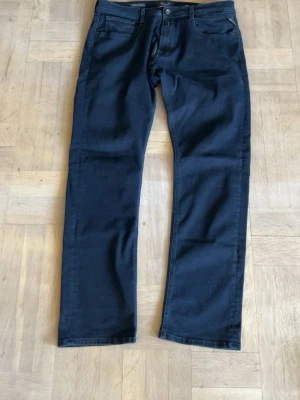 Svarta raka Replay  jeans  - Snygga svarta jeans med rak passform och klassisk femficksdesign. Jeansen har normal midja och stängs med knapp och dragkedja. Perfekta för en stilren look och passar till det mesta.