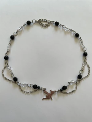 Halsband med berlock - Handgjort halsband med pärlor, kedjor och silverfärgad berlock💕