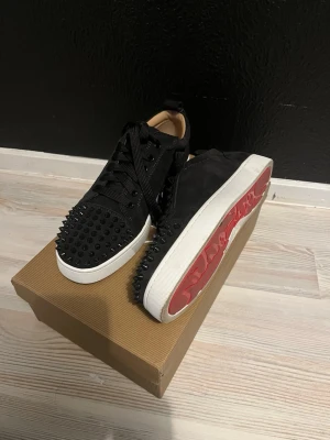Svarta Louboutin sneakers med nitar - säljer nu mina skor då jag använt dem i på ett sparsamt skick. Allt på bild följs med och tvättas såklart innan jag fraktar😇 Hör av er vid frågor🙌🏻