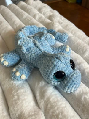 Baby blå drake  - Denna urgulliga deake är virkad av mig🩵🥰 Det är en babyblå drake virkat med mjukt garn från Rusta som heter Klara🫶🏼 Den har hårda blåa ögon som inte går att ta av, sitter som bergen✨🩵 Den är cirka 54 cm lång🩵