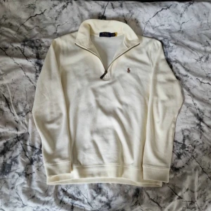 Ralph Lauren half zip  - Klassisk Ralph Lauren tröja med lite tunnare material som passar perfekt nu när sommaren är runt hörnet. Använt ett fåtal gånger vilket ger helt ny känsla på plagget. Färgen är cream aktig som får den se lyxigare ut. Mått på sista bilden: A: 53cm B:65cm C:62cm D: 44cm