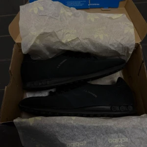 Säljer ett par Adidas LA Trainer Triple Black i bra använt skick - Size 42 2/3 EU - Skorna är använda och har lätt slitage på insidan av hälen (se bild 6), utan påverkan på funktionen. I övrigt är skorna i fint skick. Originalkartong medföljer.