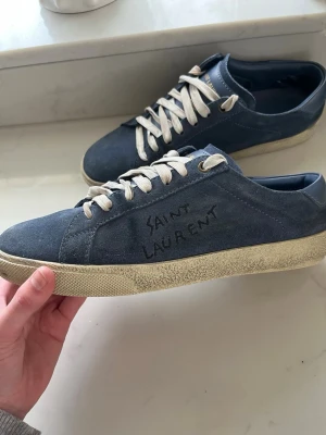 Mörkblå Saint Laurent skor - Säljer dessa sjukt snygga saint laurent skor i mörkblå, storlek 38 men passar 39-39,5. Innersula är 25,5cm. Fraktar samma dag som köp, man får även med mörkblå snören. Skriv vid frågor eller funderingar 👊