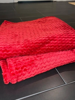 Röd mjuk filt med vågmönster - Fluffig filt från rusta, helt ny utan prislapp bara. Ca 160*200cm